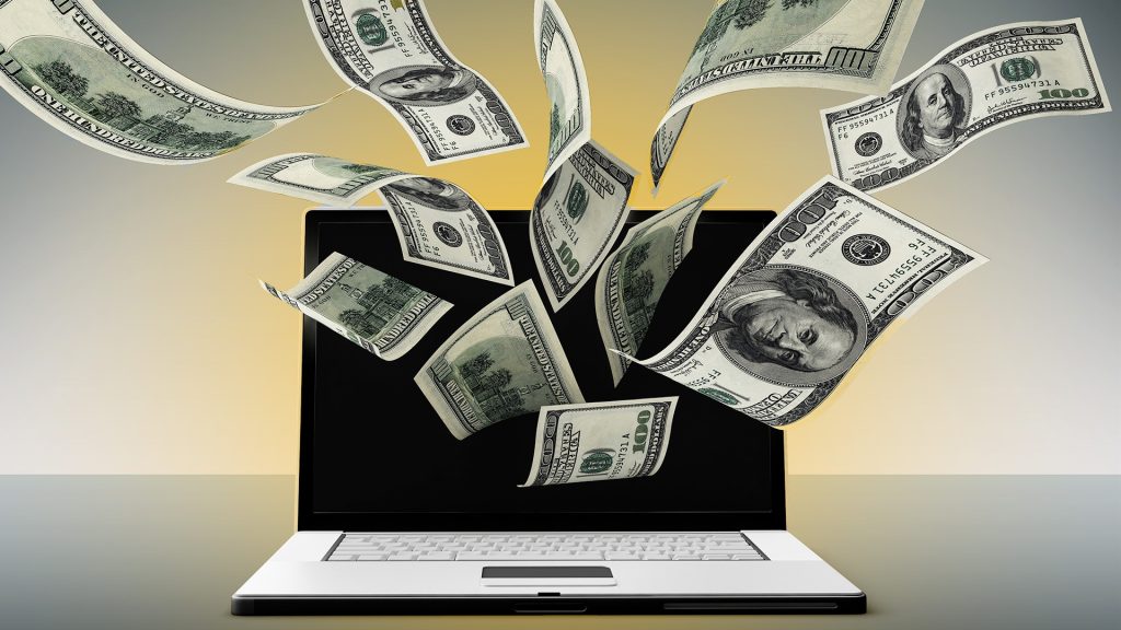 Money dollar bills coming out of a laptop screen